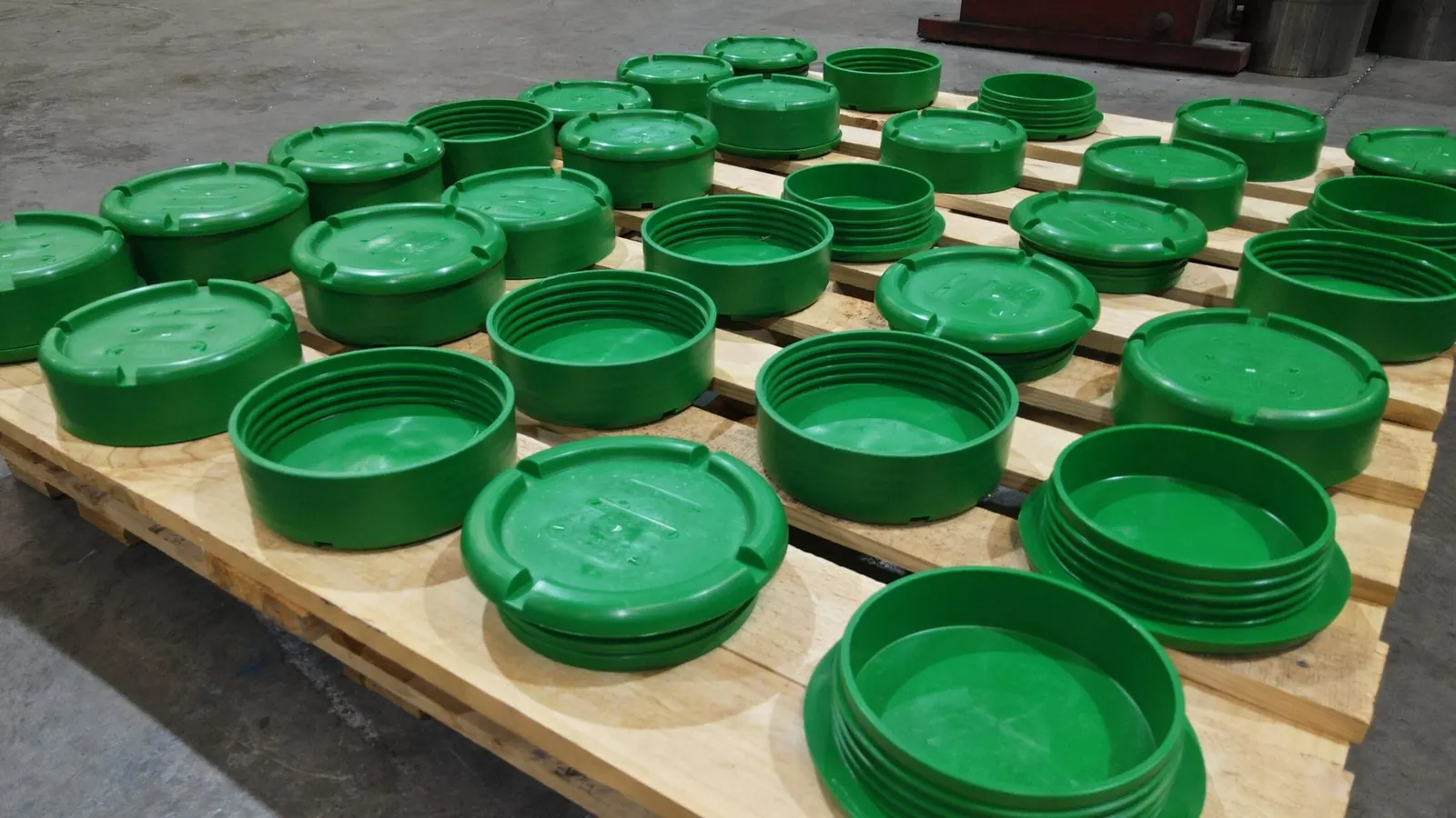 Freshly moulded green flange covers on a pallet